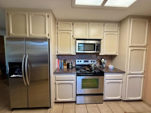 31117 Longview Ln E, Coarsegold, CA 93614 - kitchen with appliances with stainless steel finishes, light tile patterned floors, decorative backsplash, and dark stone counters