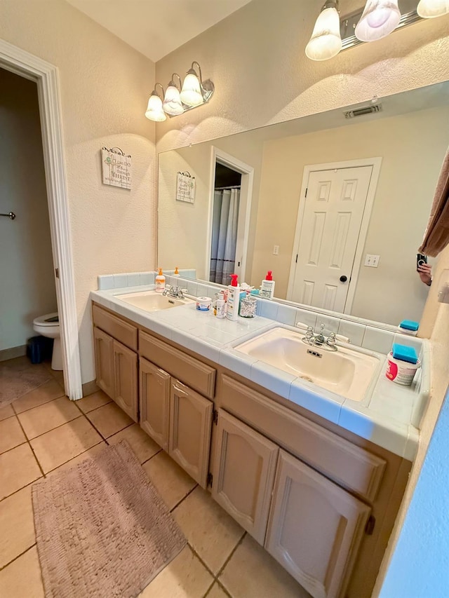31117 Longview Ln E, Coarsegold, CA 93614 - bathroom with double vanity, tile patterned floors, toilet, and a textured wall