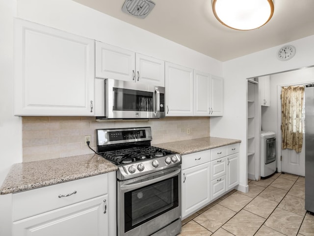 1632 W Shields Ave, Fresno, CA 93705 - kitchen with appliances with stainless steel finishes, washer / clothes dryer, decorative backsplash, and white cabinetry