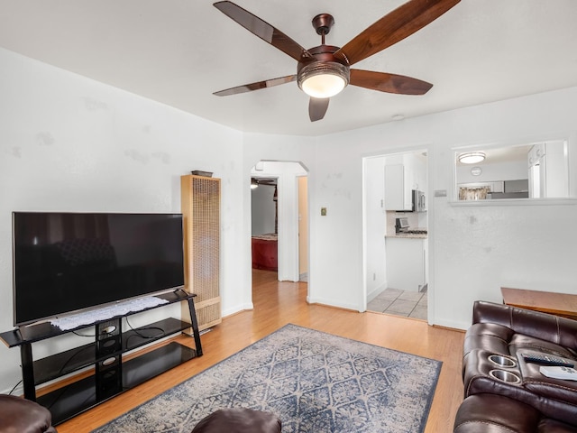 1632 W Shields Ave, Fresno, CA 93705 - living room with a heating unit, a ceiling fan, arched walkways, wood finished floors, and baseboards