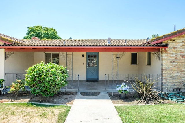 1438 E Rialto Ave, Fresno, CA 93704 - property entrance with stucco siding, a tiled roof, and brick siding