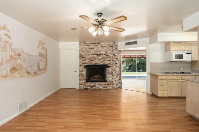 1438 E Rialto Ave, Fresno, CA 93704 - unfurnished living room with light wood-style floors, a ceiling fan, a brick fireplace, and baseboards