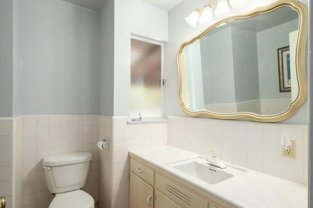 1438 E Rialto Ave, Fresno, CA 93704 - half bath featuring vanity, toilet, a wainscoted wall, and tile walls