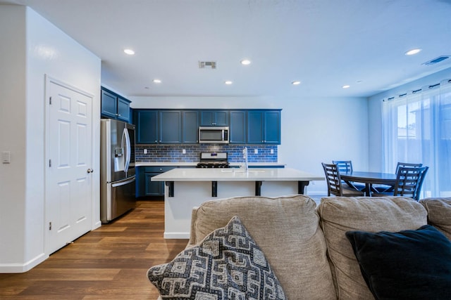 6659 E Vassar Ave, Fresno, CA 93727 - kitchen with appliances with stainless steel finishes, open floor plan, dark wood-style flooring, light countertops, and decorative backsplash