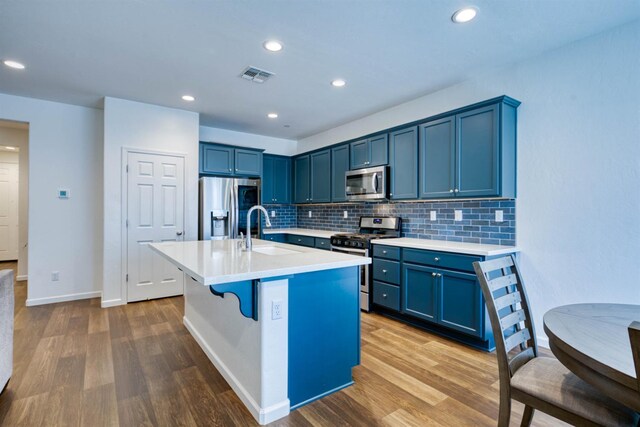 6659 E Vassar Ave, Fresno, CA 93727 - kitchen with appliances with stainless steel finishes, a sink, blue cabinets, wood finished floors, and recessed lighting