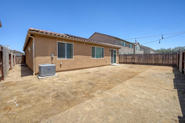 6659 E Vassar Ave, Fresno, CA 93727 - back of property featuring central AC unit, stucco siding, a fenced backyard, and a tiled roof
