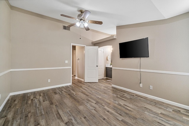 10131 N Price Ave, Fresno, CA 93730 - unfurnished bedroom with lofted ceiling, arched walkways, wood finished floors, and baseboards