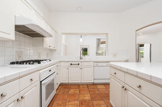 2189 W Via Delfini, Fresno, CA 93711 - kitchen with white appliances, tile counters, range hood, a sink, and decorative backsplash