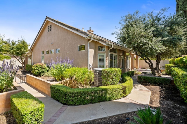2189 W Via Delfini, Fresno, CA 93711 - view of home's exterior featuring stucco siding and a chimney