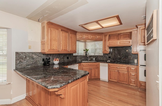 311 S Fowler Ave, Fowler, CA 93625 - kitchen with a sink, a peninsula, light wood-style flooring, decorative backsplash, and plenty of natural light