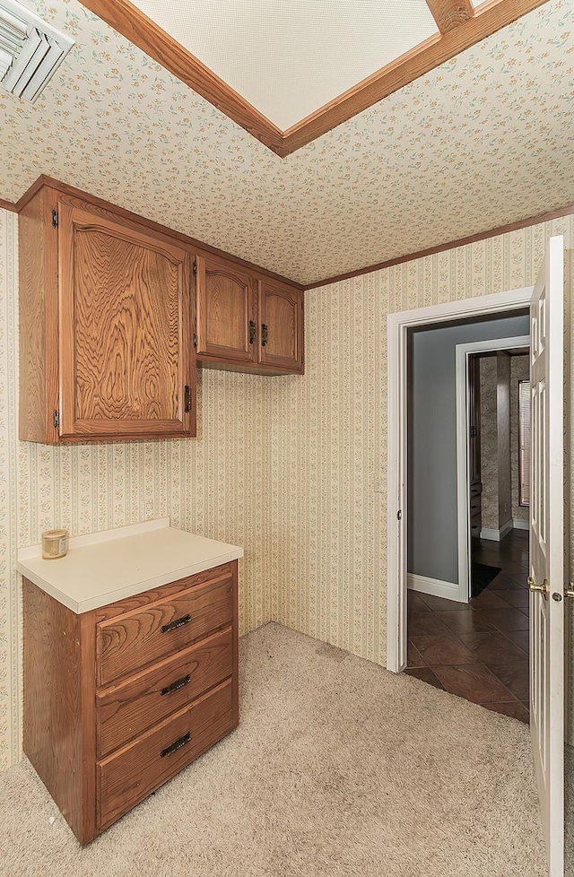311 S Fowler Ave, Fowler, CA 93625 - kitchen with brown cabinets, light countertops, wallpapered walls, and light colored carpet