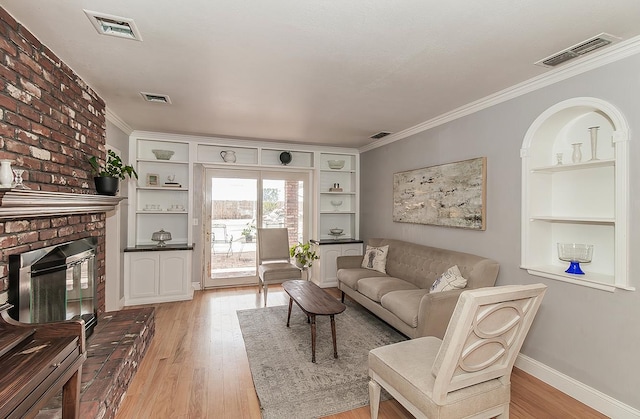 311 S Fowler Ave, Fowler, CA 93625 - living area featuring light wood finished floors, ornamental molding, built in shelves, baseboards, and a fireplace