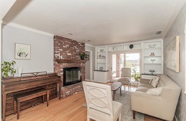 311 S Fowler Ave, Fowler, CA 93625 - living room with light wood-style flooring, a fireplace, built in features, and crown molding