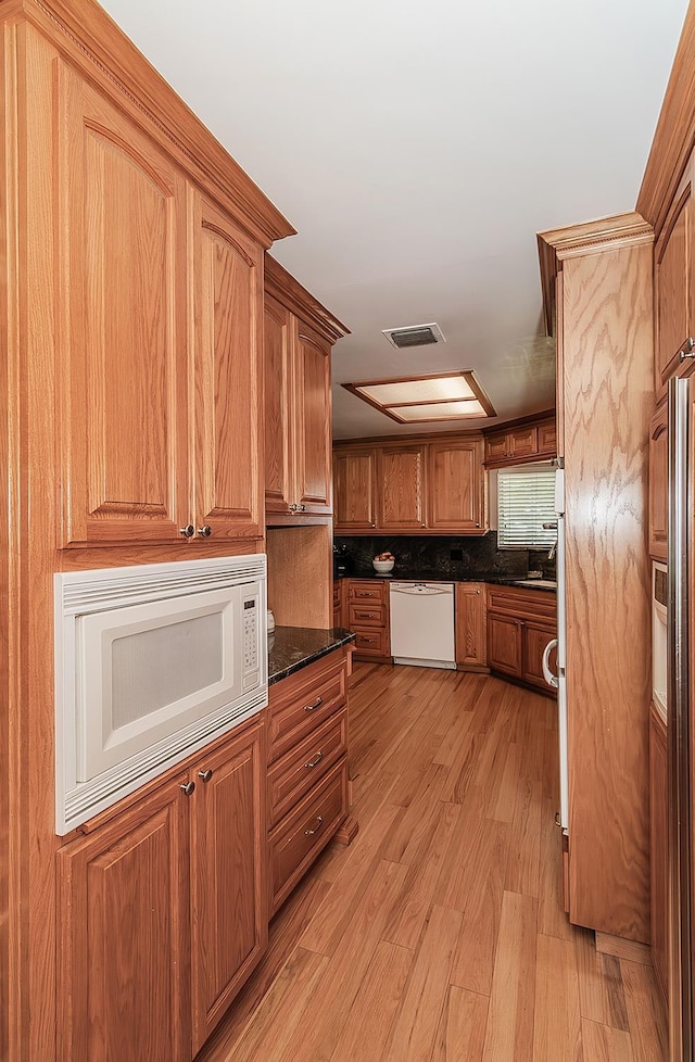 311 S Fowler Ave, Fowler, CA 93625 - kitchen with white appliances, light wood-type flooring, and brown cabinets