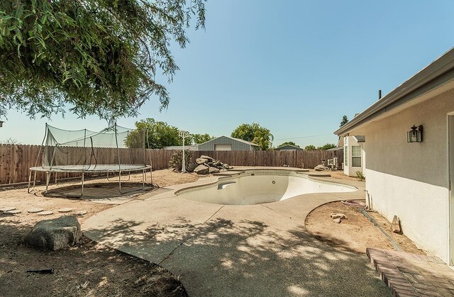 311 S Fowler Ave, Fowler, CA 93625 - fenced backyard with a trampoline and a patio area