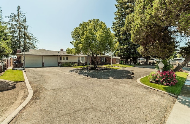 311 S Fowler Ave, Fowler, CA 93625 - ranch-style home featuring a garage, driveway, and a chimney