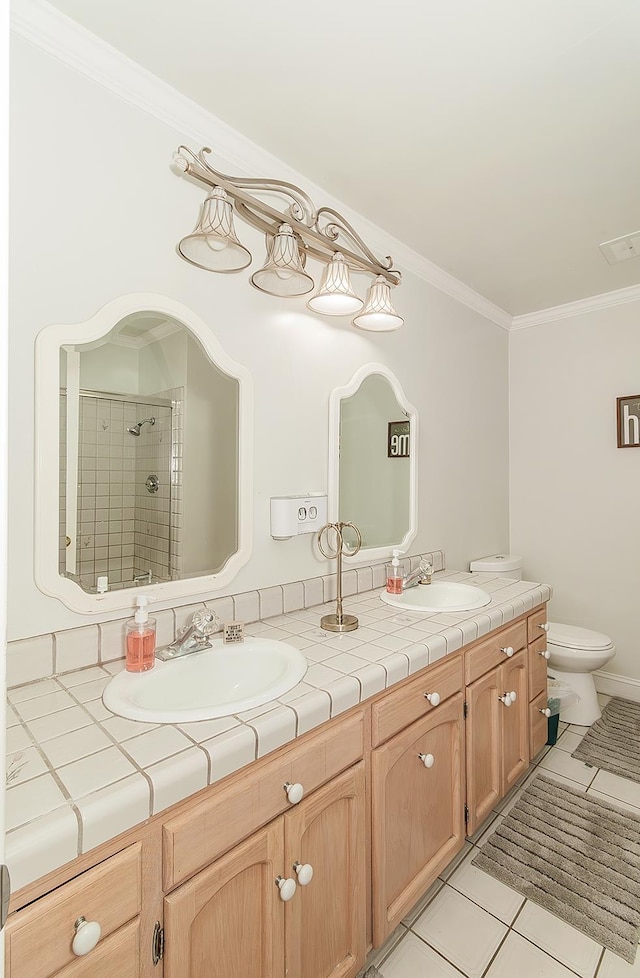 311 S Fowler Ave, Fowler, CA 93625 - full bathroom featuring double vanity, ornamental molding, a stall shower, tile patterned flooring, and toilet