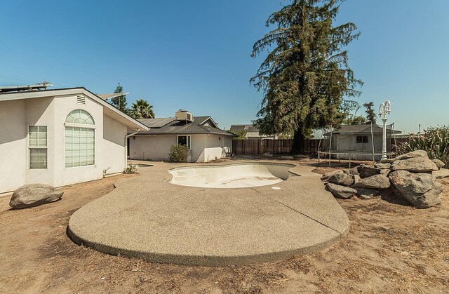 311 S Fowler Ave, Fowler, CA 93625 - fenced backyard featuring a trampoline and a patio