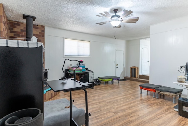101 S Princeton Ave, Coalinga, CA 93210 - home office with a wood stove, wood finished floors, a ceiling fan, and a textured ceiling