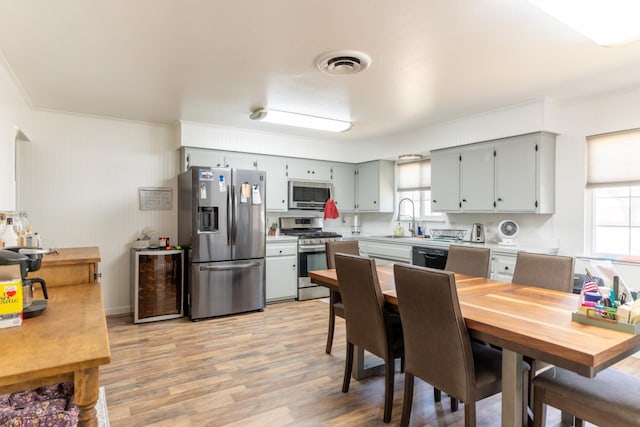 101 S Princeton Ave, Coalinga, CA 93210 - kitchen with appliances with stainless steel finishes, beverage cooler, plenty of natural light, a sink, and ornamental molding