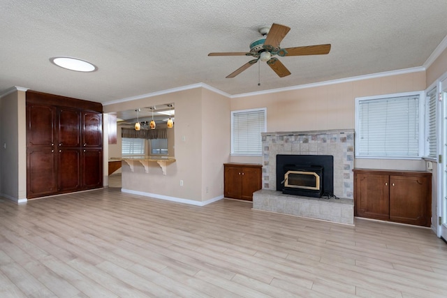 450 W Alluvial Ave, Clovis, CA 93611 - unfurnished living room featuring a textured ceiling, baseboards, a ceiling fan, crown molding, and light wood-style flooring