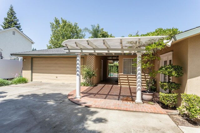 450 W Alluvial Ave, Clovis, CA 93611 - view of front facade featuring an attached garage, stucco siding, driveway, and a pergola