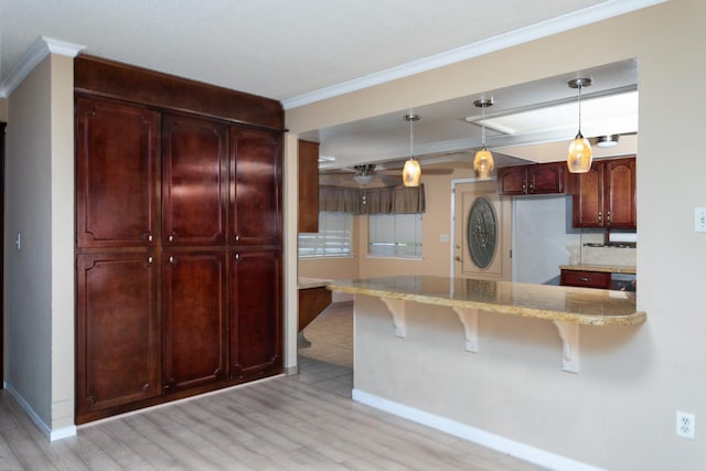 450 W Alluvial Ave, Clovis, CA 93611 - kitchen with crown molding, a breakfast bar area, light stone counters, baseboards, and light wood-style flooring