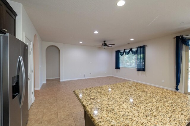 3083 N Stanley Ave, Fresno, CA 93737 - kitchen with stainless steel refrigerator with ice dispenser, a ceiling fan, arched walkways, light stone countertops, and recessed lighting