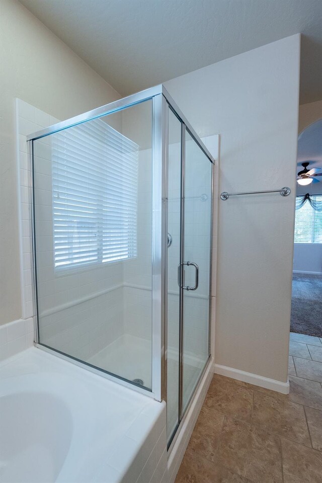 3083 N Stanley Ave, Fresno, CA 93737 - bathroom featuring a stall shower, a garden tub, ceiling fan, and baseboards