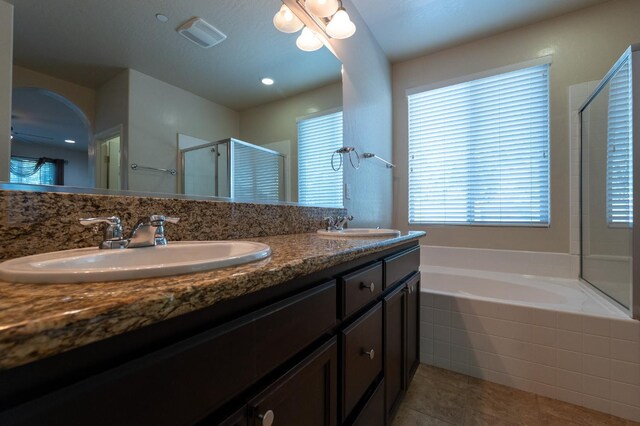 3083 N Stanley Ave, Fresno, CA 93737 - bathroom featuring a stall shower, double vanity, a bath, and tile patterned floors
