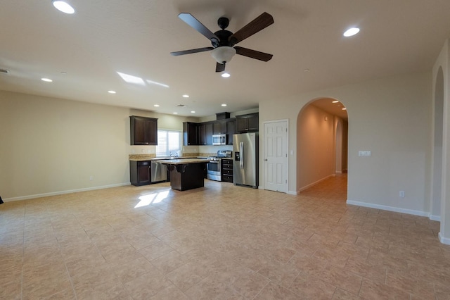 3083 N Stanley Ave, Fresno, CA 93737 - unfurnished living room with arched walkways, a ceiling fan, baseboards, and recessed lighting