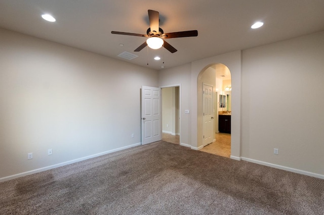 3083 N Stanley Ave, Fresno, CA 93737 - unfurnished bedroom featuring light colored carpet, arched walkways, recessed lighting, baseboards, and ensuite bath