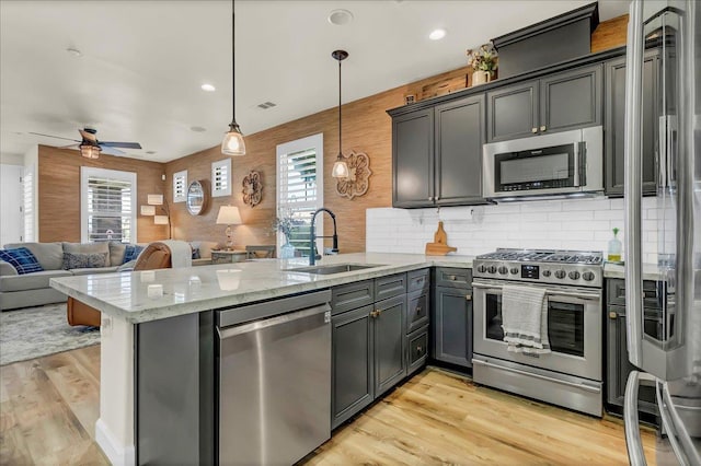 1281 W Walter Ave Unit 15, Fowler, CA 93625 - kitchen featuring appliances with stainless steel finishes, a sink, a peninsula, open floor plan, and light stone countertops