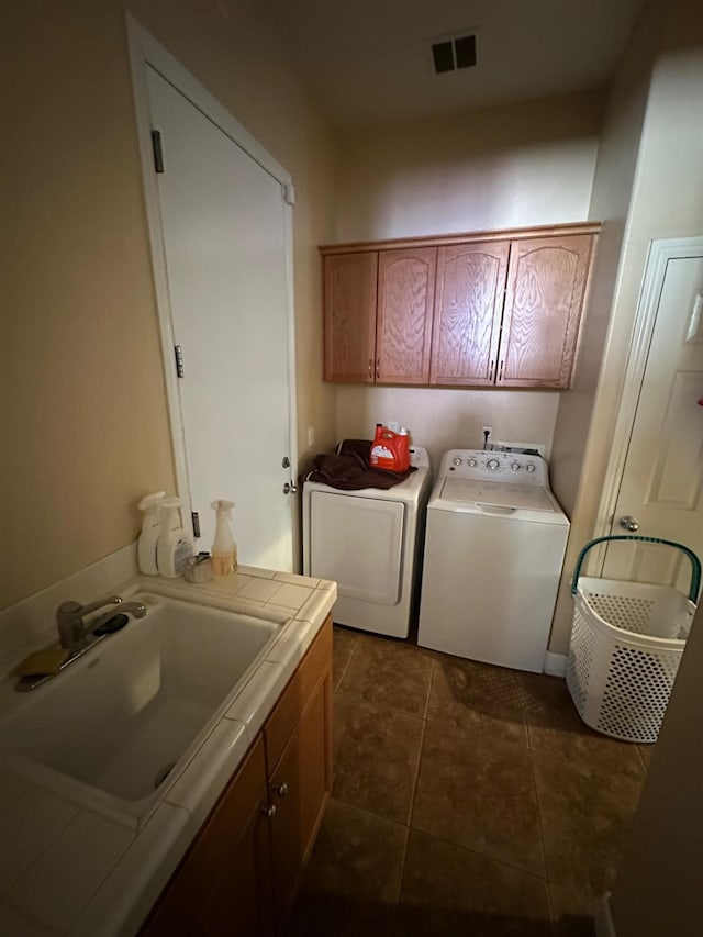5804 W Chennault Ave, Fresno, CA 93722 - laundry room featuring cabinet space, washer and dryer, and dark tile patterned floors