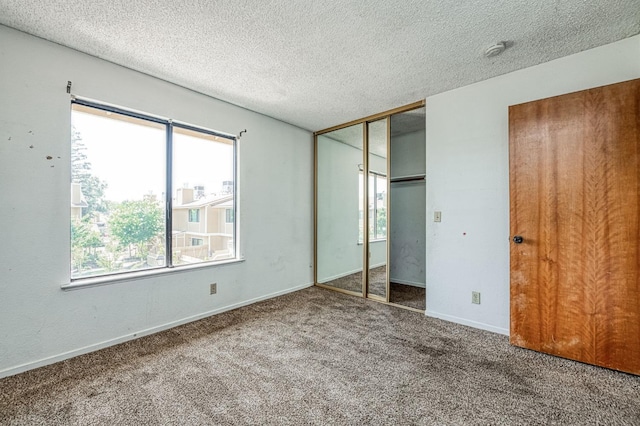4885 N Backer Ave Unit 151, Fresno, CA 93726 - unfurnished bedroom featuring multiple windows, carpet flooring, a textured ceiling, a closet, and baseboards