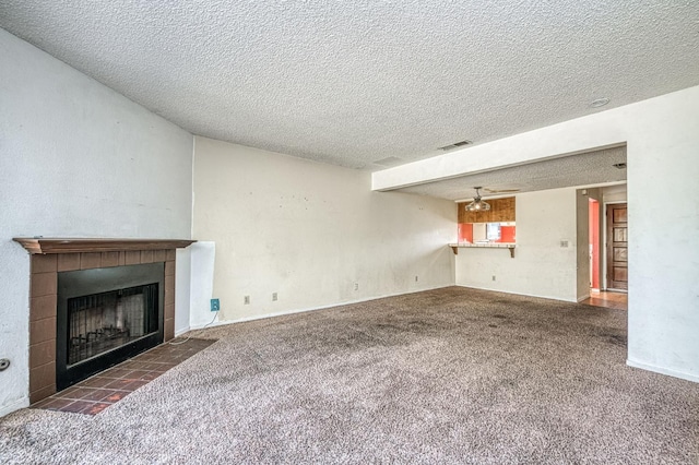 4885 N Backer Ave Unit 151, Fresno, CA 93726 - unfurnished living room featuring a tiled fireplace, carpet floors, and a textured ceiling