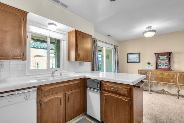 5072 N Forkner Ave, Fresno, CA 93711 - kitchen with dishwasher, a sink, a peninsula, tasteful backsplash, and brown cabinetry