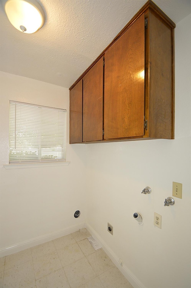 4779 N Cedar Ave # 109, Fresno, CA 93726 - laundry area featuring electric dryer hookup, cabinet space, gas dryer hookup, baseboards, and a textured ceiling