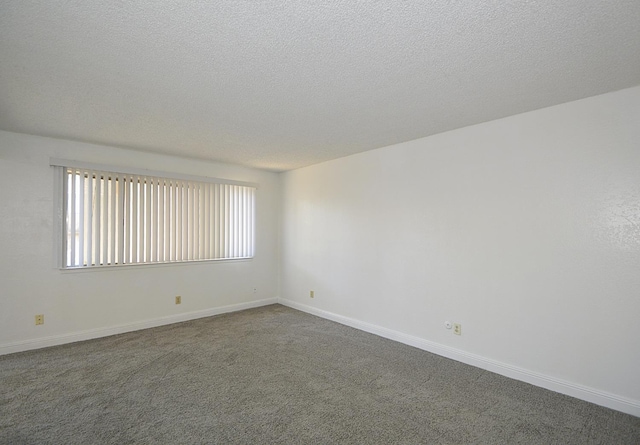 4779 N Cedar Ave # 109, Fresno, CA 93726 - spare room featuring dark colored carpet, a textured ceiling, and baseboards