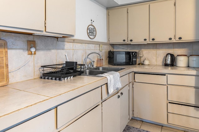 1586 N Calaveras St, Fresno, CA 93728 - kitchen featuring black microwave, a sink, tile countertops, and decorative backsplash