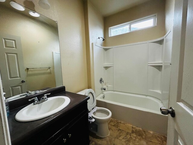 5795 E Beck Ave, Fresno, CA 93727 - full bath with vanity, toilet, washtub / shower combination, and stone finish flooring
