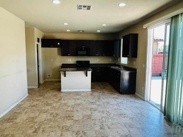 5795 E Beck Ave, Fresno, CA 93727 - kitchen featuring black microwave, dark cabinets, a sink, baseboards, and dark countertops