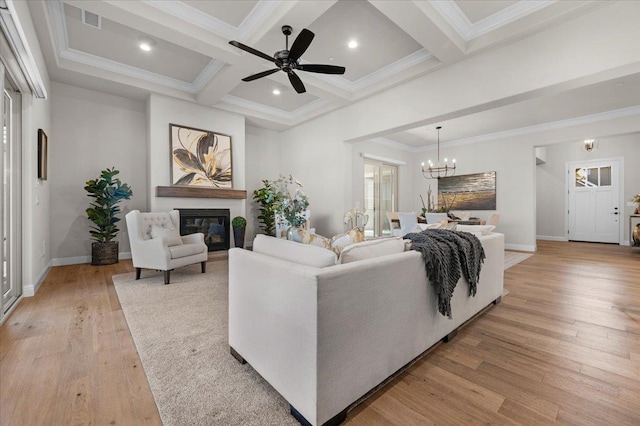 11753 N Turf Dr, Fresno, CA 93730 - living area with a glass covered fireplace, light wood-style floors, coffered ceiling, beam ceiling, and a chandelier