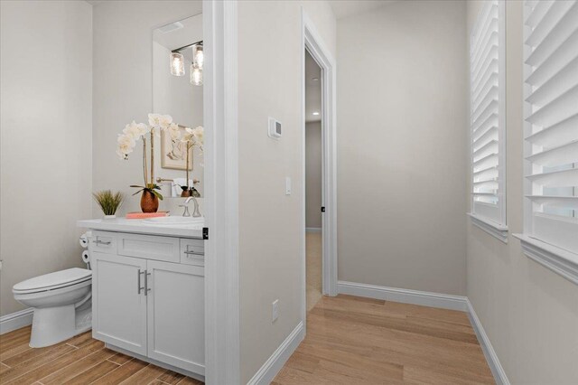 11753 N Turf Dr, Fresno, CA 93730 - bathroom featuring vanity, wood finished floors, toilet, and baseboards