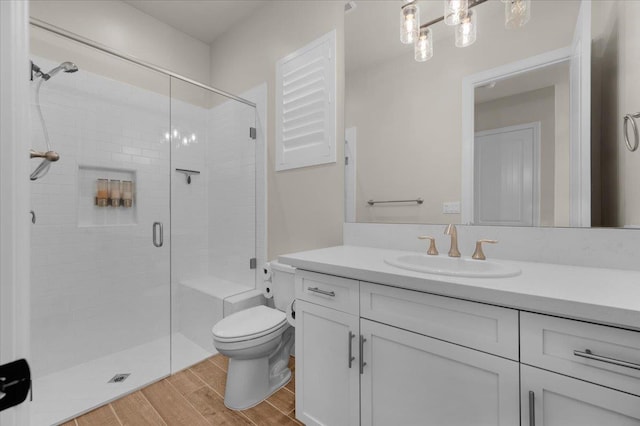 11753 N Turf Dr, Fresno, CA 93730 - bathroom with wood finished floors, vanity, a stall shower, and toilet