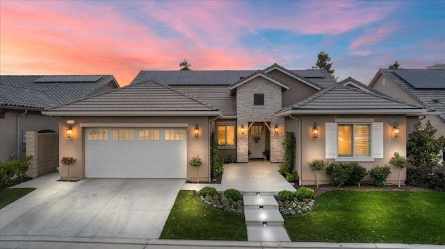 11753 N Turf Dr, Fresno, CA 93730 - traditional-style home featuring an attached garage, concrete driveway, a lawn, stucco siding, and roof mounted solar panels