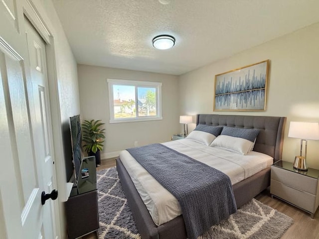 1310 Fresno St, Madera, CA 93638 - bedroom with wood finished floors, a textured ceiling, and baseboards