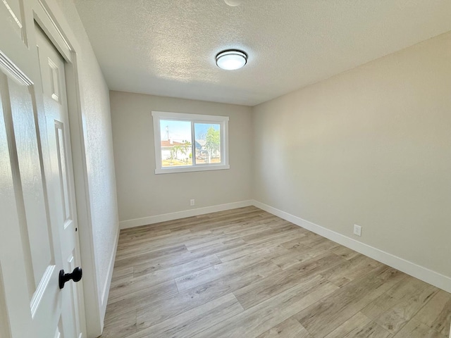 1310 Fresno St, Madera, CA 93638 - empty room featuring light wood-style flooring, a textured ceiling, and baseboards