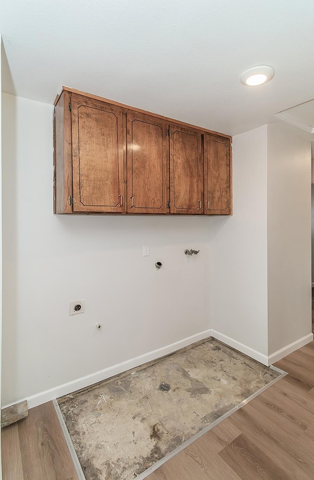 709 Keith St, Lemoore, CA 93245 - washroom featuring light wood finished floors, hookup for an electric dryer, gas dryer hookup, and cabinet space
