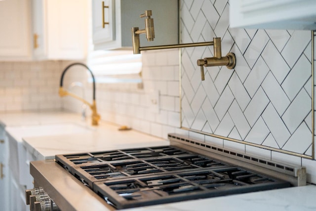2048 W Sierra Ave, Fresno, CA 93711 - kitchen view of backsplash, stainless steel gas range, light countertops, and white cabinetry